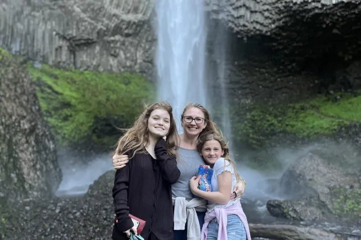 a woman standing next to a waterfall