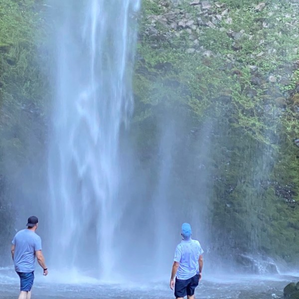 a group of people standing next to a waterfall