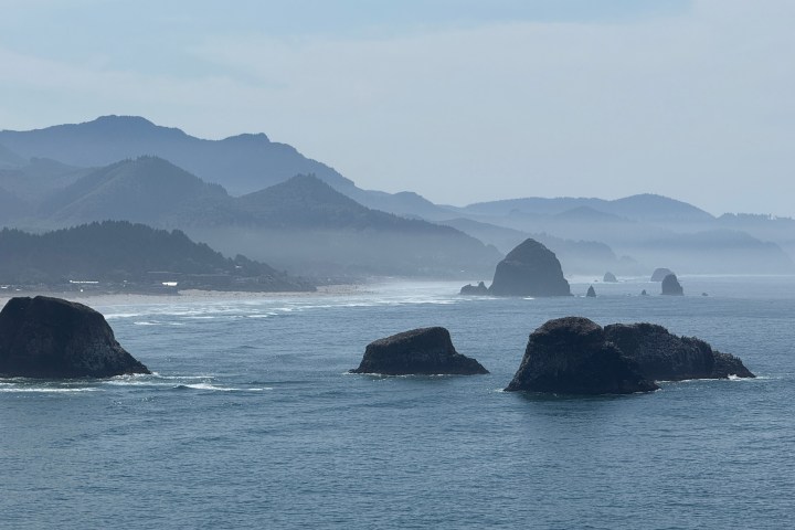 Coastal view with rocky islands and misty mountains in the background